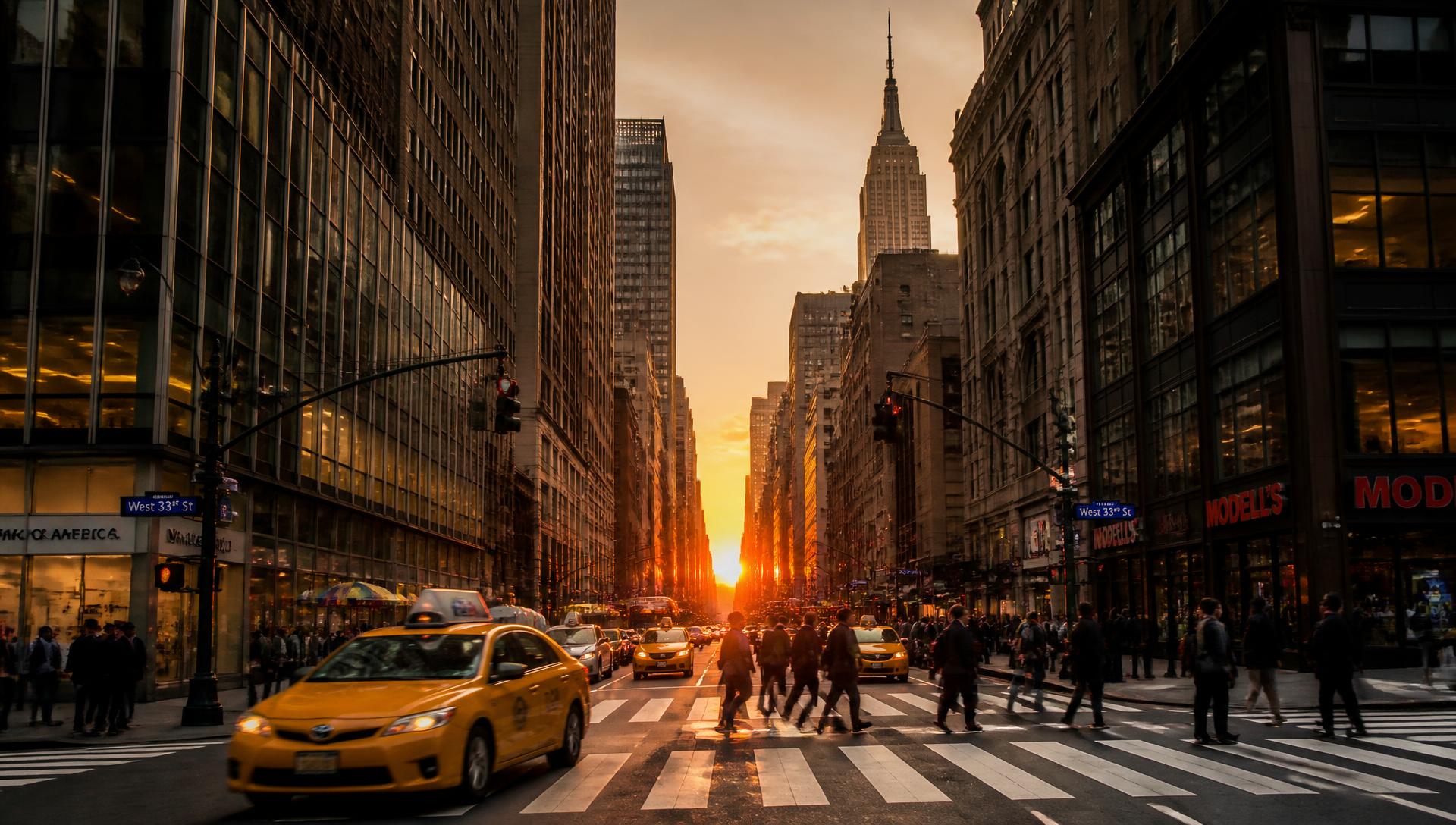 Midtown Manhattan street at sunset with taxis and pedestrians crossing
